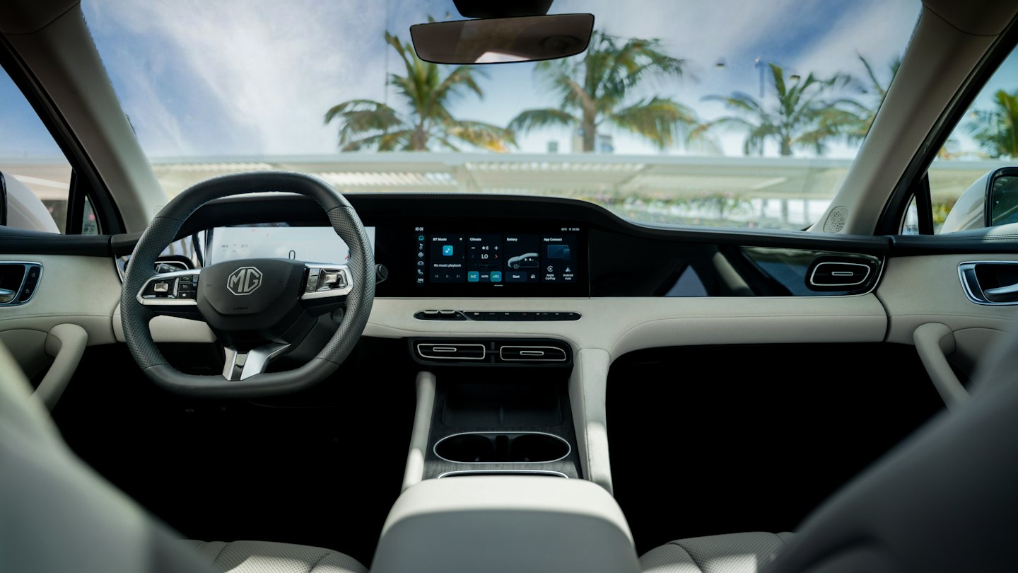Šiuolaikinis automobilio prietaisų skydelis su skaitmeniniu ekranu ir matomomis palmėmis.